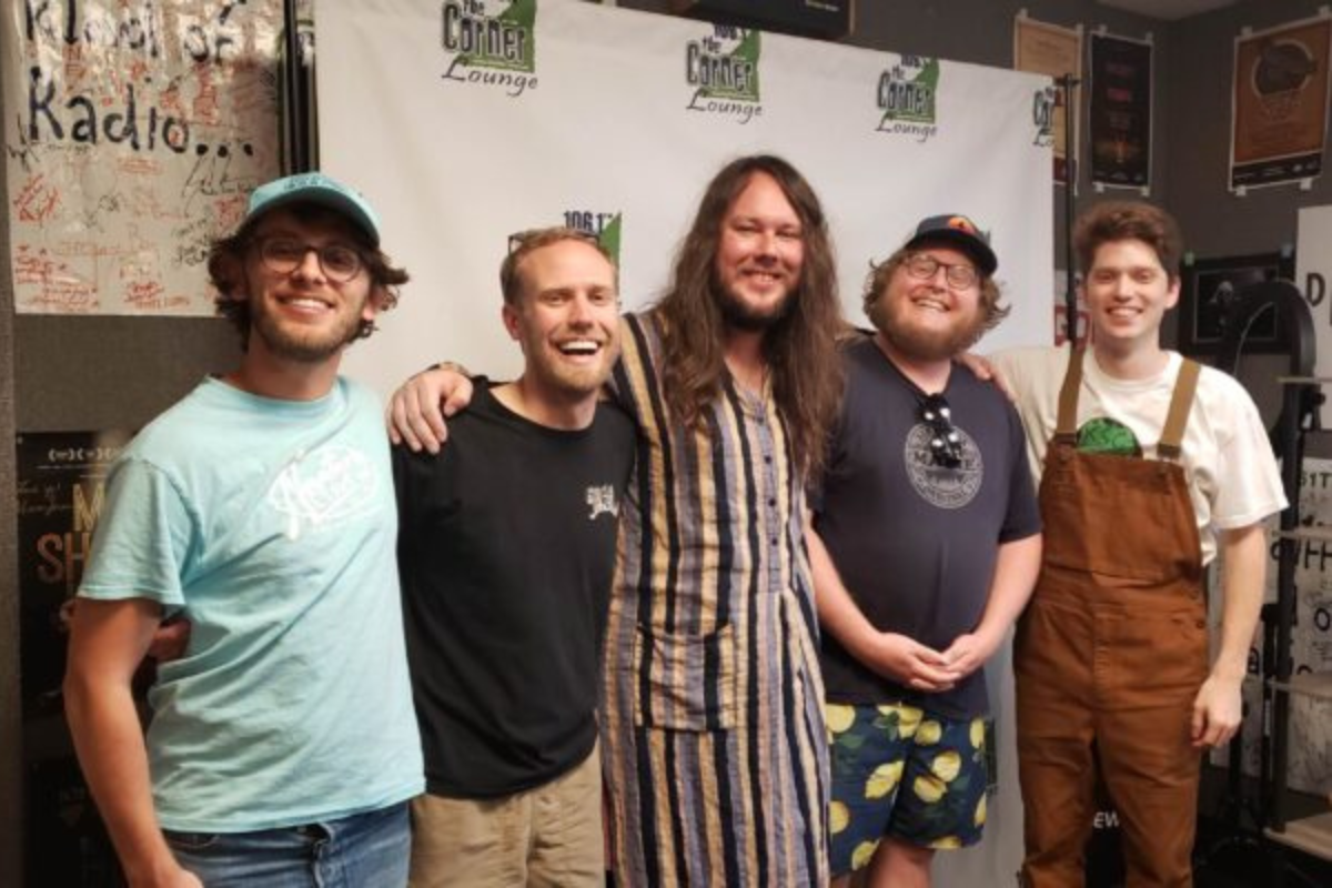 All five members of Kendall Street Company band smile at camera in the Corner studio.