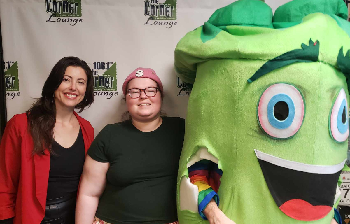 The Falsies singer Carter on the left, host Samantha in the middle, person in broccoli mascot suit on the right