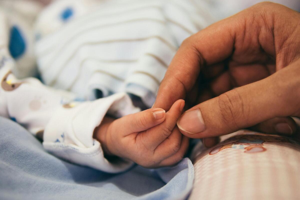 person holding child's finger