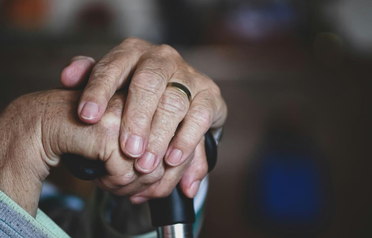Two hands holding a cane.