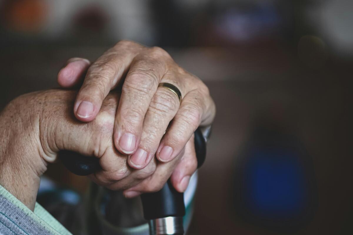 Two hands holding a cane.