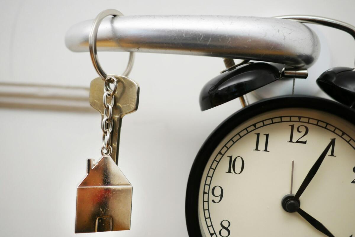House Key on doorknob with a clock in the lower right hand corner.