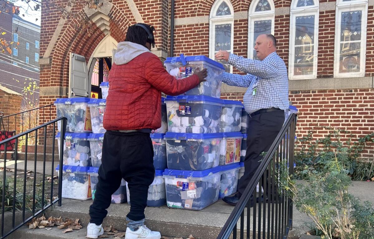 Volunteers helps unload bins of socks at The Haven.