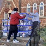Volunteers helps unload bins of socks at The Haven.