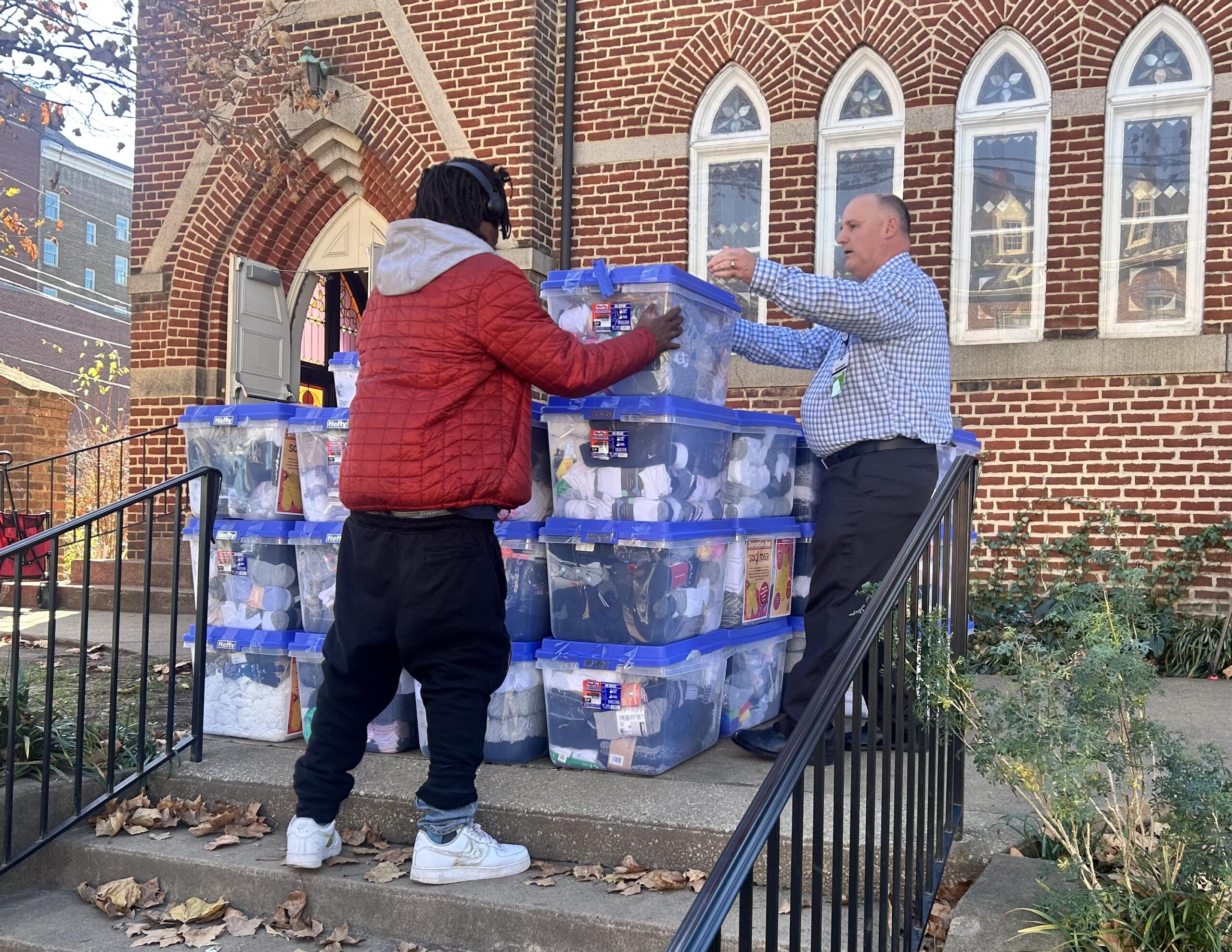 Volunteers helps unload bins of socks at The Haven.