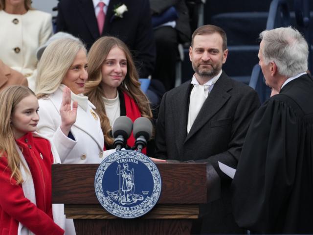 William C Mims administers oath of office to Spanberger with her family surrounding her