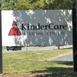 Outdoor KinderCare Learning Centers sign with red logo, mounted on tall black posts.
