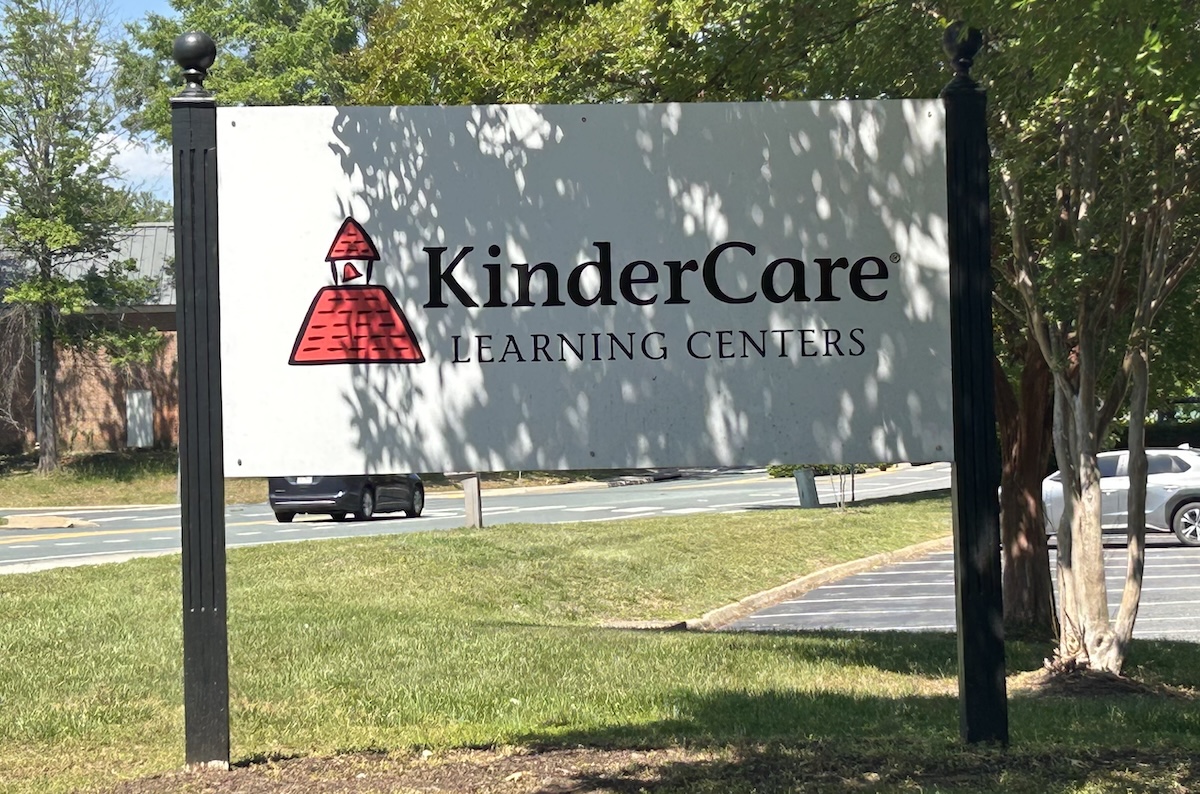 Outdoor KinderCare Learning Centers sign with red logo, mounted on tall black posts.