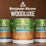 Three Benjamin Moore WoodLuxe paint cans in front of a brown backdrop, with a white WoodLuxe logo on top.