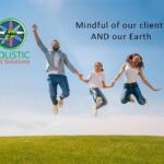Family of three jumping in the air on a grassy hill with Holistic Pest Solutions logo on the left and the slogan 'Mindful of our clients AND our Earth' on the sky background.