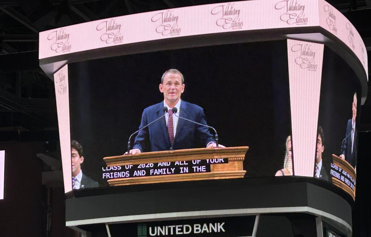 Male speaker at a wooden podium delivering a speech on a large curved LED stage with United Bank signage visible beneath.