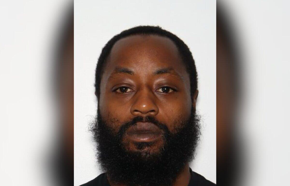 Portrait of a man with a full beard and short hair, facing the camera against a plain light background, neutral expression.