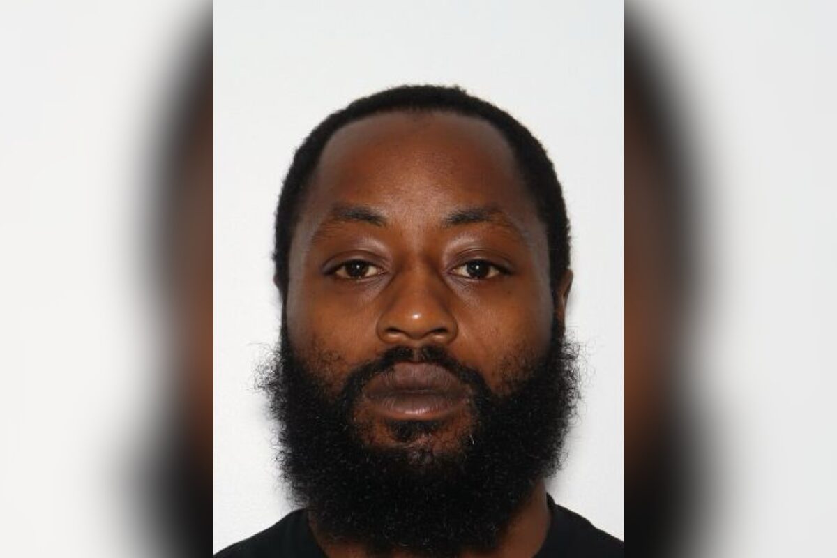 Portrait of a man with a full beard and short hair, facing the camera against a plain light background, neutral expression.