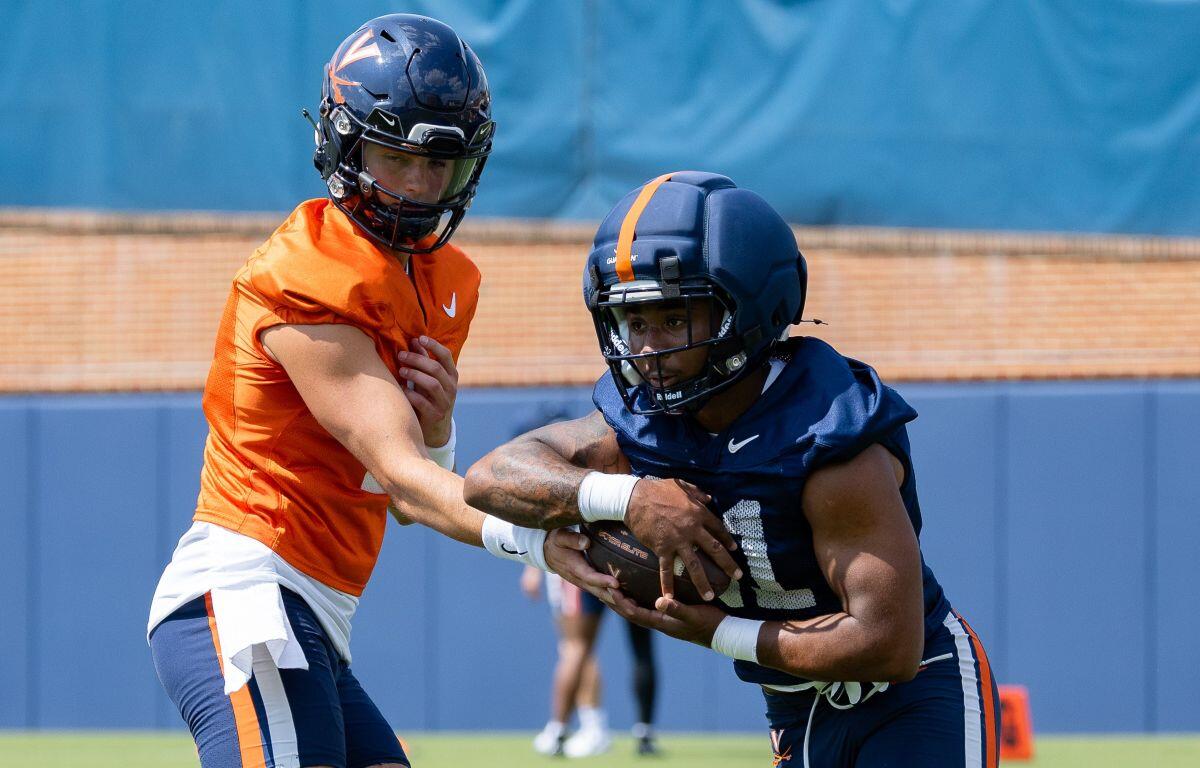 QB Beau Pribula (left) hands the ball off to RB Jekail Middlebrook (right)
