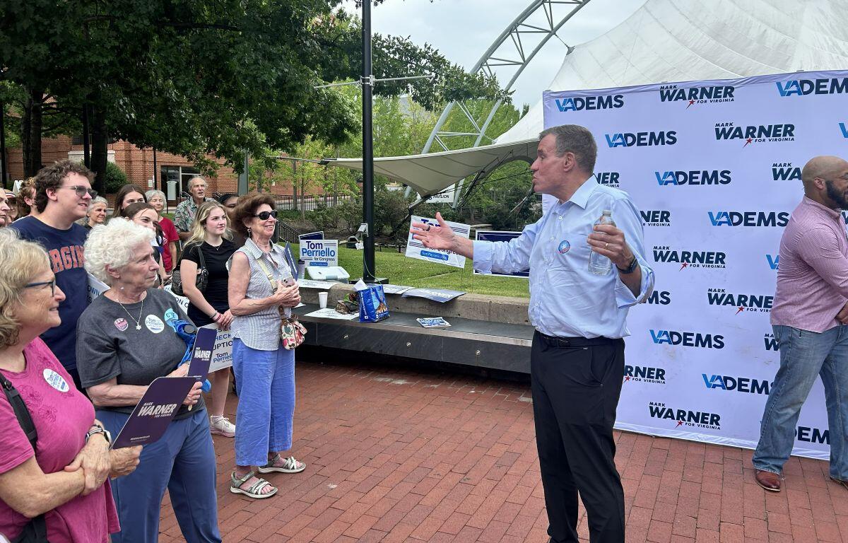 Sen. Mark Warner (right) speaks to supporters in Charlottesville.