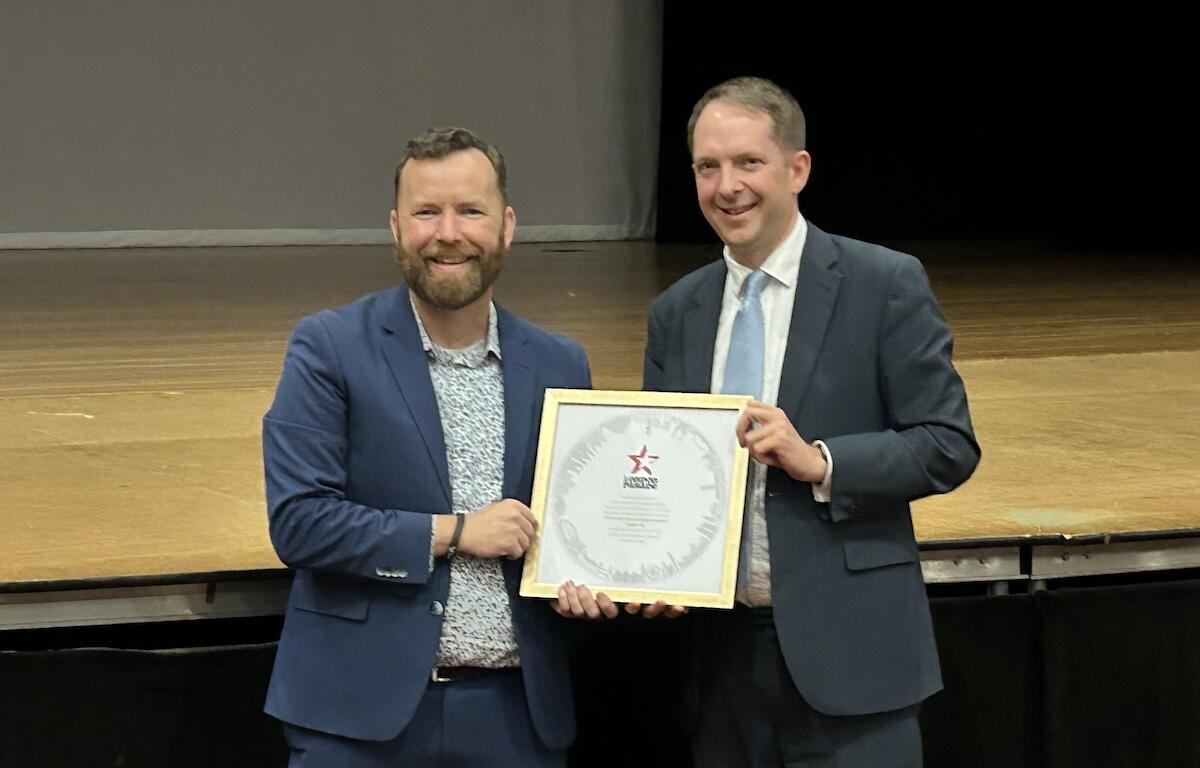 Director of Bands Jason Hackworth (left) accepts the official invitation to the parade from Deputy Lieutenant for Greater London Steve Summers (right).