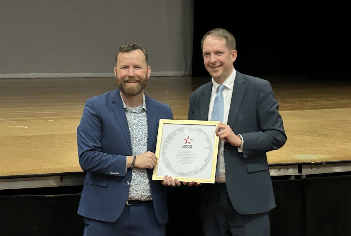 Director of Bands Jason Hackworth (left) accepts the official invitation to the parade from Deputy Lieutenant for Greater London Steve Summers (right).